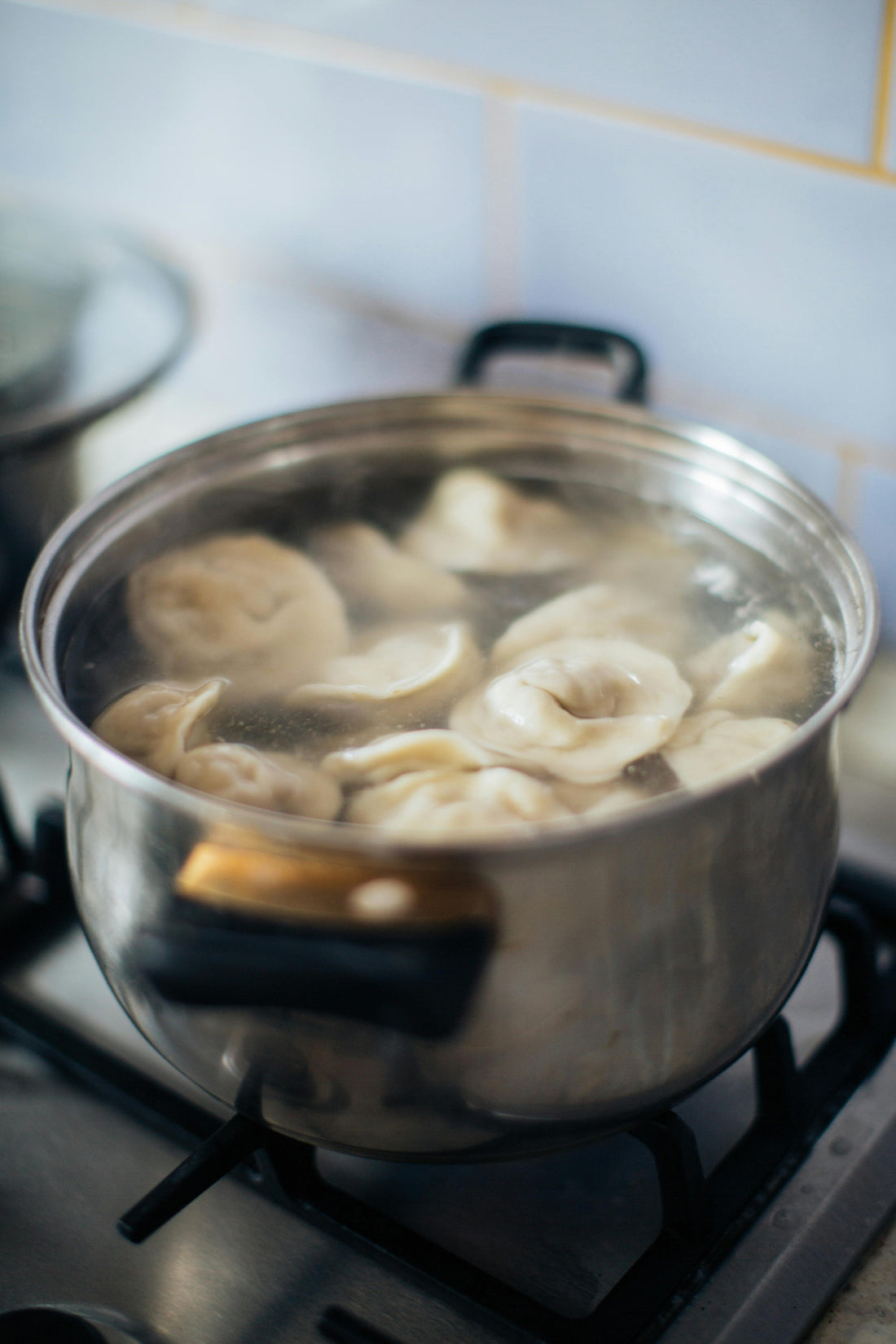 Frozen chicken dumplings (russian style), boiling in water. By Daa! Dumplings NYC.